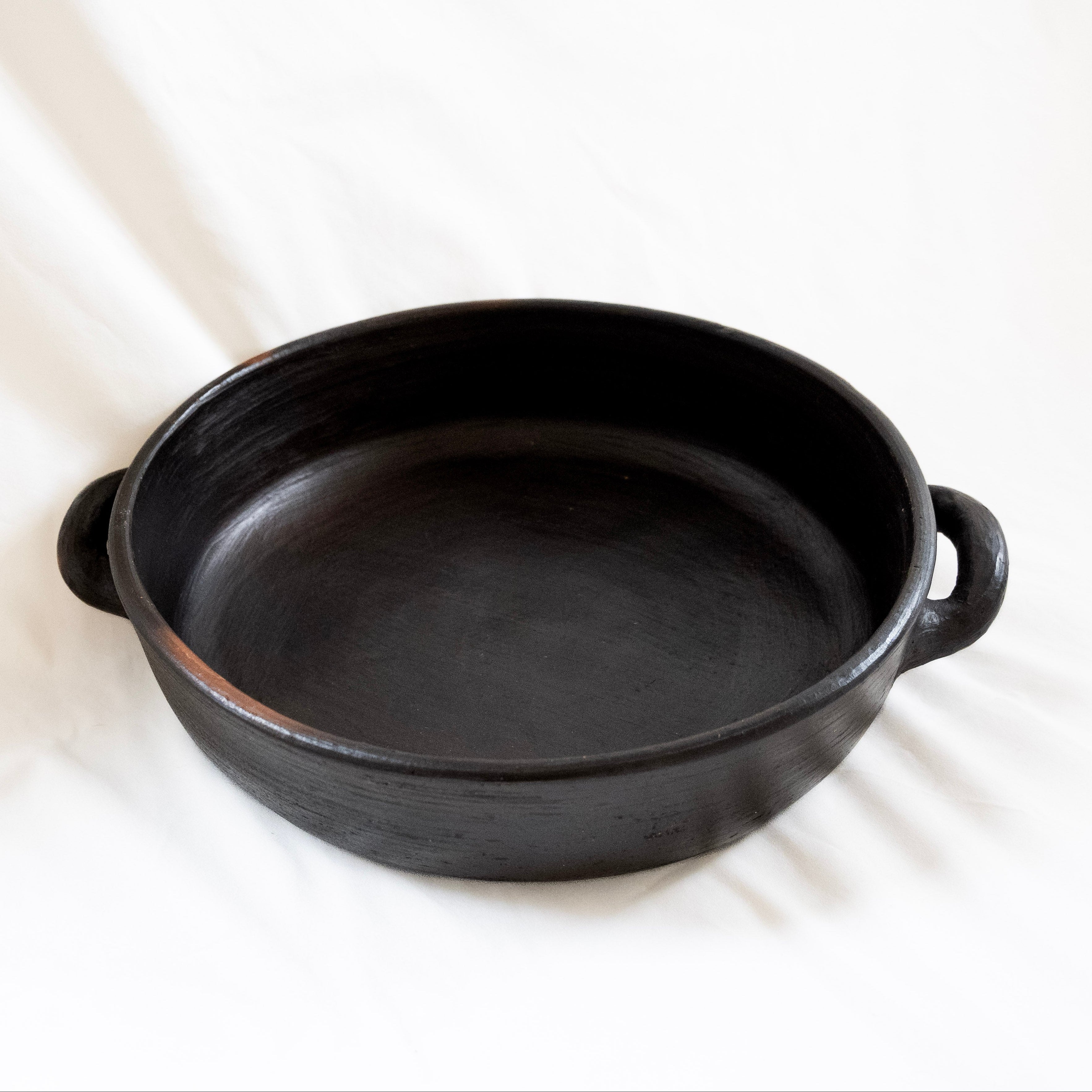 Round, black ceramic baking dish. 